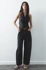 Top negro de satén con cuello halter drapeado ajustable con lazada en el cuello y espalda descubierta con lazada.