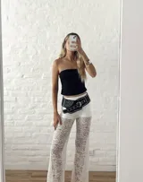 Pantalón ancho de encaje blanco con diseño floral, tiro alto y elástico en la cintura.