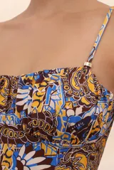Traje de baño entero con estampado abstracto en tonos marrón, amarillo y celeste. Tiene breteles finos y escote recto con fruncido.