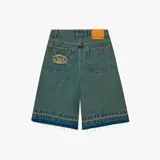 Short de jean azul con corte ancho, bolsillos delanteros y traseros, y ruedo desflecado. Presenta un parche con el logo de la marca en uno de los bolsillos traseros y etiqueta de cuero en la cintura.