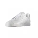 Championes Adidas Gazelle de cuero blanco con las tres tiras laterales y el logo en dorado.