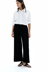 Pantalón negro de punto con textura, corte holgado, tiro alto, piernas rectas, elástico revestido en la cintura y cordón para ajustar.