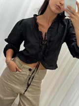 Blusa color blanco de lino, con mangas 3/4 y volados en el frente. Se ata con lazos en el centro.