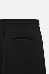 Pantalón jogger gris de corte recto, confeccionado en tejido de algodón compacto con interior en rizo. Cuenta con cintura elástica ajustable con cordón interior, bolsillos frontales y bolsillo de doble vivo en la espalda.