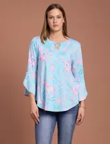Blusa de seda fría estampada con flores en tonos celeste y rosa, marca Ruby Rd. Tiene cuello redondo con escote en V entrelazado y mangas 3/4 acampanadas.