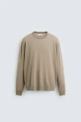 Jersey de hombre color beige claro, tejido en lana, de corte recto, cuello redondo y mangas largas con terminaciones en rib.