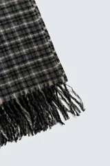 Bufanda rectangular con estampado de cuadros en tonos gris, negro y beige. Termina en flecos.