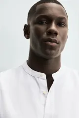 Camisa color beige claro de lino y algodón, corte relaxed fit, cuello mao, manga larga con puños abotonados y cierre frontal con botones. Marca Zara.