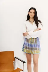 Minifalda de viscosa con estampado batik en tonos azul, violeta y amarillo. Cintura elastizada con cordón de ajuste.