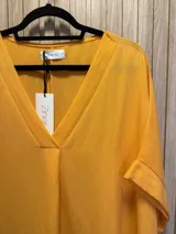 Blusa negra de corte holgado con escote en V y mangas cortas con dobladillo.