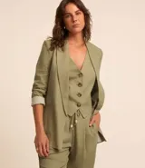 Blazer largo color beige confeccionado en viscosa y lino, con cuello solapa, bolsillos y forro estampado a rayas.