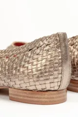 Zapato chata color dorado, trenzado a mano en cuero vacuno, con capellada, forro y plantilla de cuero vacuno.