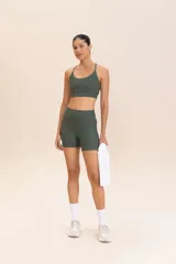 Top deportivo verde oliva con tirantes finos cruzados en la espalda y relleno extraíble.