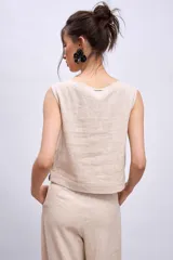 Chaleco celeste con diseño cruzado y doble botonadura, sin mangas y con apliques de encaje en los laterales.