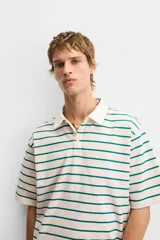 Polo de hombre corte relaxed fit, con cuello solapa y cierre frontal de botonadura. Diseño a rayas horizontales color verde sobre fondo blanco.