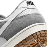 Zapatillas Nike Dunk Low Retro SE, color gris y blanco con suela marrón.