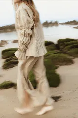 Camisa color beige de lino, corte holgado, manga larga con puños fruncidos y cuello clásico.