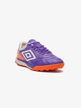 Championes de fútbol Umbro, color violeta con detalles en naranja y blanco. Presentan un diseño texturizado en la parte delantera y el logo de Umbro en los laterales. La suela es de color naranja con tapones para césped sintético.