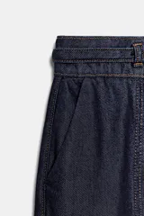 Jeans de tiro alto con corte bootcut, confeccionados en denim azul oscuro. Presentan costuras verticales decorativas en el frente, bolsillos laterales y cinturón del mismo tejido con hebilla metálica.