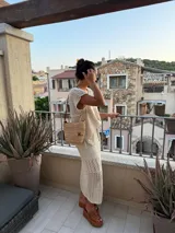 Pollera midi color crudo, de tejido calado con abertura lateral y cintura elastizada con cordón.