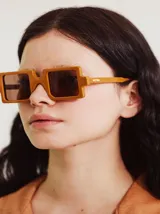 Lentes de sol en color turquesa con un diseño cuadrado y lentes oscuros, hechos en Italia.