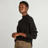Sweater negro de punto suave con cuello alto y corte holgado.