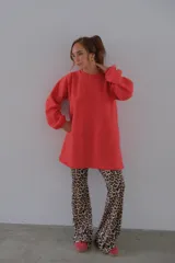 Conjunto de sweater color beige de corte holgado y pantalón acampanado con estampado animal print.