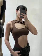 Body marrón con corte asimétrico, un hombro descubierto, abertura en el pecho y en el abdomen.