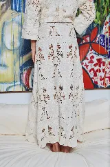 Falda larga color crudo con textura de encaje de algodón, corte evasé y cintura ajustable con cordones.