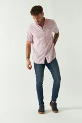 Camisa de manga corta color beige claro, confeccionada en lino y algodón, con cuello abotonado, bolsillo en el pecho y logo bordado. Corte semi slim.