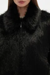 Campera de abrigo color beige claro, con textura de pelo largo y suave, cuello solapa y cierre frontal.