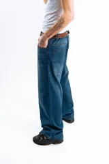 Pantalón de denim azul desgastado, corte mega baggy con bolsillos grandes y botones personalizados.
