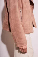 Campera color rosa viejo, estilo motociclista, confeccionada en gamuza sintética con cierre asimétrico y detalles de tachas.