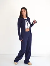 Pantalón de vestir azul marino, de corte recto, con bolsillos laterales y traseros. Se ajusta a la cintura con cinturón de cuero marrón.