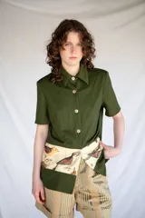 Camisa verde militar de manga corta con botones nacarados y corte estampado en el delantero con diseño de aves.