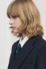 Blazer de lana azul marino con cuello solapa de muescas y manga larga acabada en abertura y botones. Tiene bolsillos con solapa en delantero y de vivo en pecho, forro interior a tono y cierre frontal cruzado con botones.