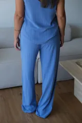 Pantalón de corte recto confeccionado en una mezcla de lino y viscosa, color azul francia con sutiles rayas verticales. Presenta cintura elástica con detalle de botones frontales y bolsillos laterales.