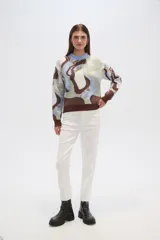 Sweater de punto con estampado abstracto en tonos marrón, celeste, blanco y verde. Tiene cuello redondo y corte holgado.