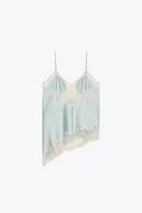 Top lencero celeste con escote en V, tirantes finos y detalle de encaje blanco en el escote y el ruedo asimétrico.