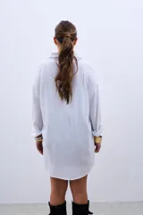 Camisa blanca de corte holgado, con cuello camisero y mangas largas. Decorada con lentejuelas de colores celeste, plateado y negro.