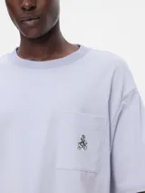 Remera azul marino de corte holgado con bolsillo en el pecho y bordado de Mickey Mouse.