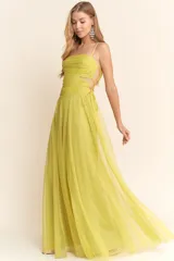 Vestido largo de fiesta color amarillo limón, con breteles finos, escote recto, corte en la cintura y falda amplia de tul. Presenta un corte lateral en la cintura y drapeado en el corpiño.