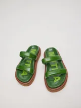 Sandalias planas de cuero vacuno verde con acabado brillante y plataforma marrón de 3 cm.