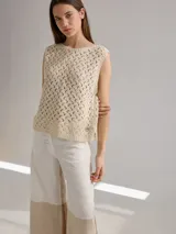 Chaleco de punto calado color beige, sin mangas y con cuello redondo.