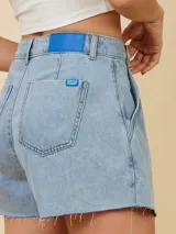 Short de jean celeste con corte irregular y ruedo desflecado.