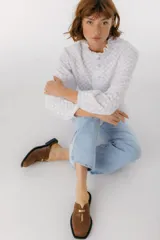 Zuecos con estampado animal print en blanco y negro, con tira ancha de cuero negro y aplique metálico.