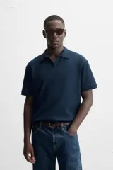 Polo azul marino de punto con textura acanalada vertical, corte regular fit, cuello solapa con abertura frontal y mangas cortas.