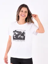 Remera blanca de algodón con cuello redondo y mangas cortas. Estampado frontal con imagen de palmeras y texto "Create New Horizons. Feeling the breeze over your skin".