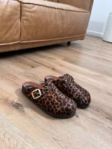 Mules de cuero con diseño de animal print en tonos marrón y negro, forrados de cuero.