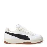 Championes Puma blancos con franja lateral negra y suela color caramelo.